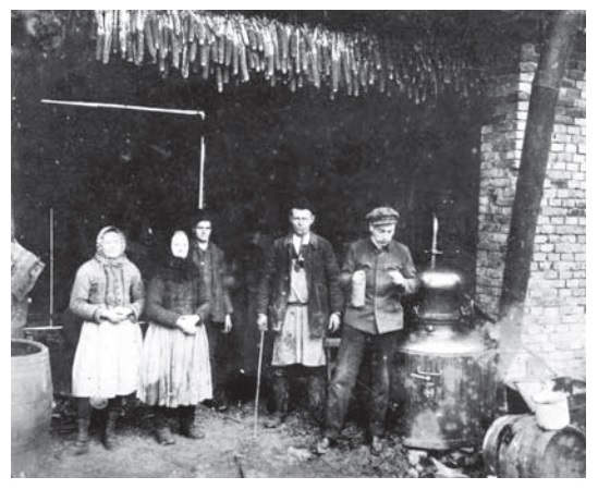 Pálení slivovice v přenosném kotli. Polešovice, kolem roku 1920. Fotoarchiv Slováckého muzea v Uherském Hradišti.